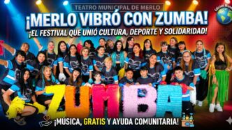 Gran grupo de vecinos y bailarines posando felices con un cartel de ZUMBA en el escenario del Teatro Municipal durante el Festival de Ritmos en Merlo.