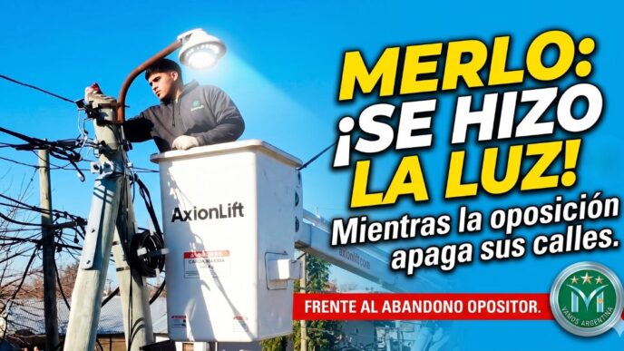 Un operario de la Municipalidad de Merlo en una hidroelevadora 'AxionLift' instalando una nueva y potente luminaria de calle bajo un cielo despejado. La imagen captura el trabajo activo de la gestión.